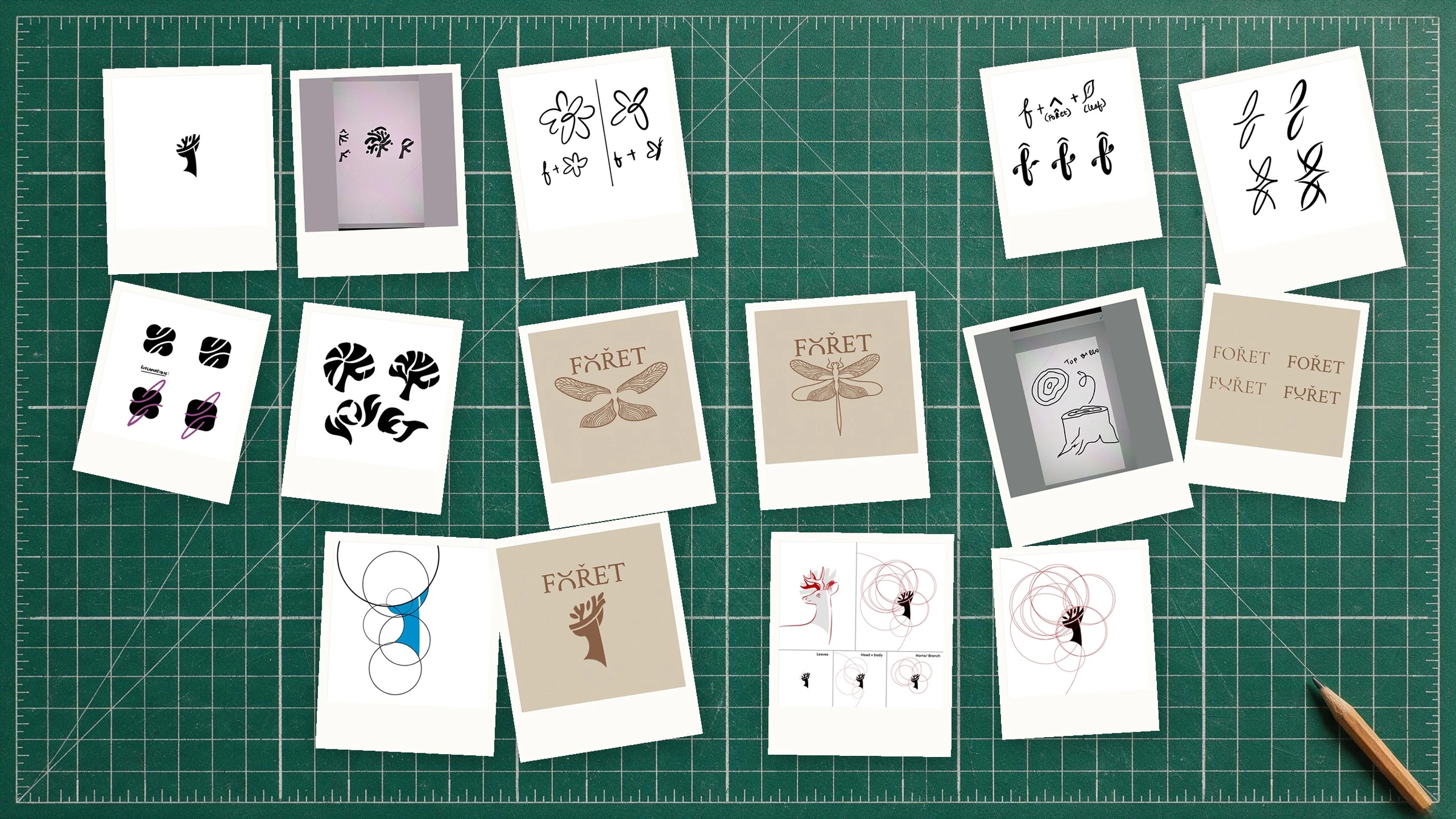 Polaroids of Foret logo drafts pinned across a studio cutting mat