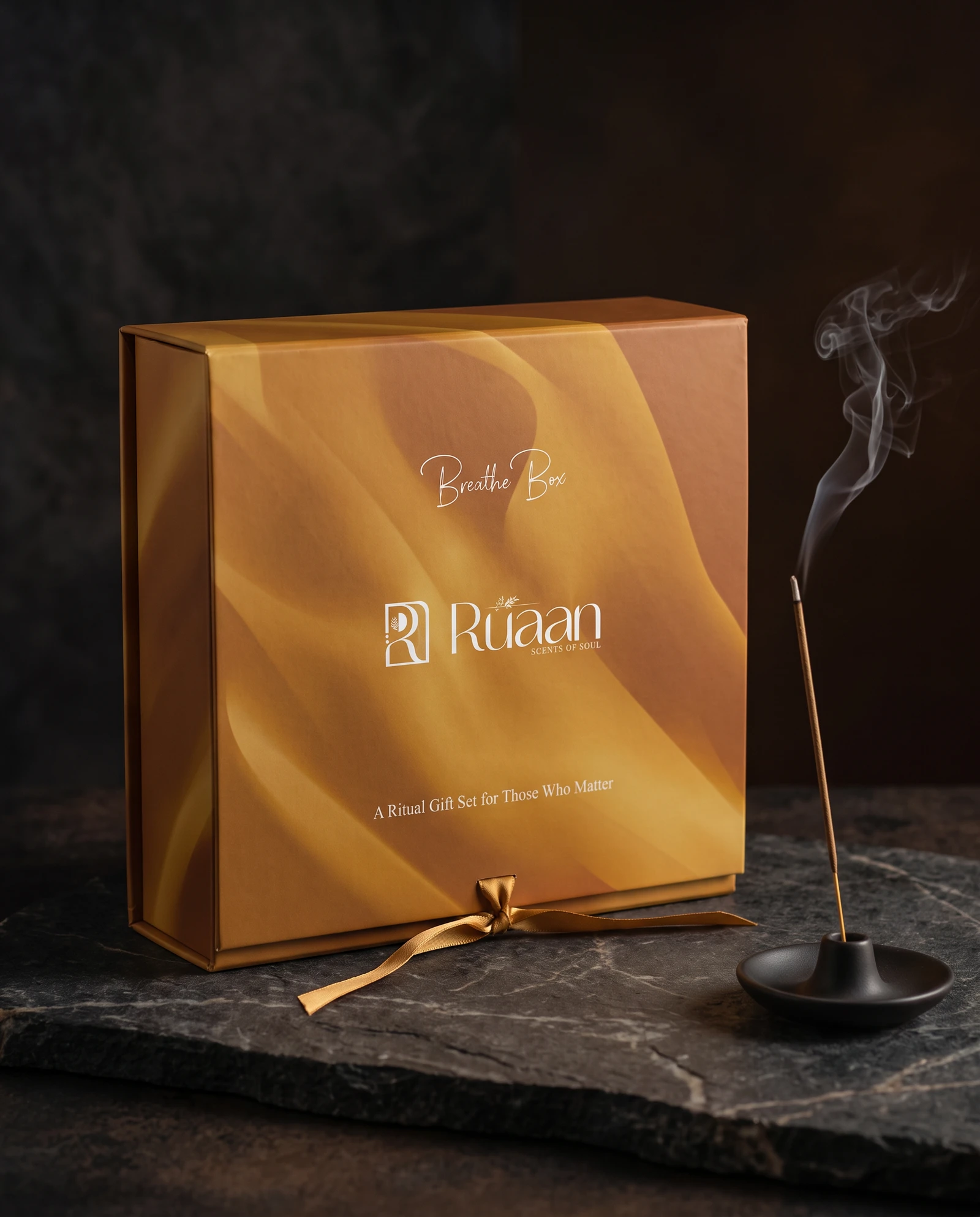 Amber Breathe Box closed on dark slate, palo santo beside it
