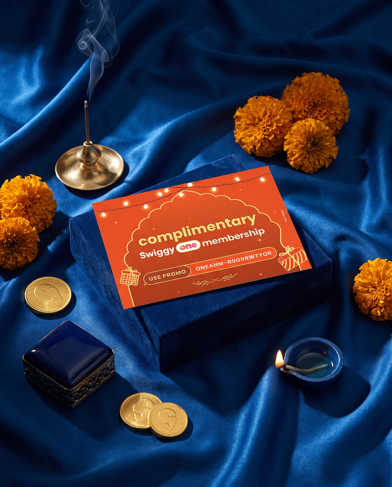 Swiggy One voucher on royal blue silk with marigolds and a coin